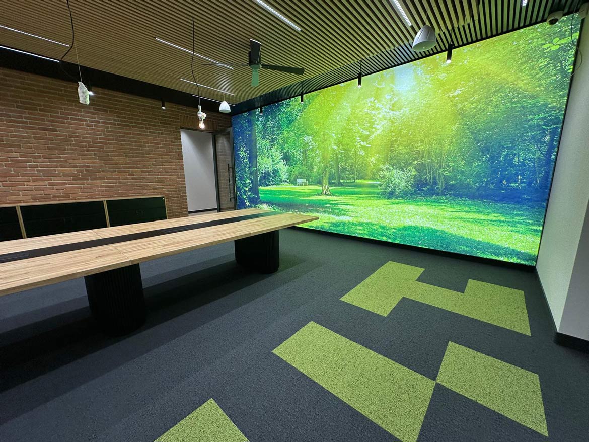 Przestrzeń coworkingowa z ceglaną ścianą, podwieszanym sufitem i industrialnym klimatem