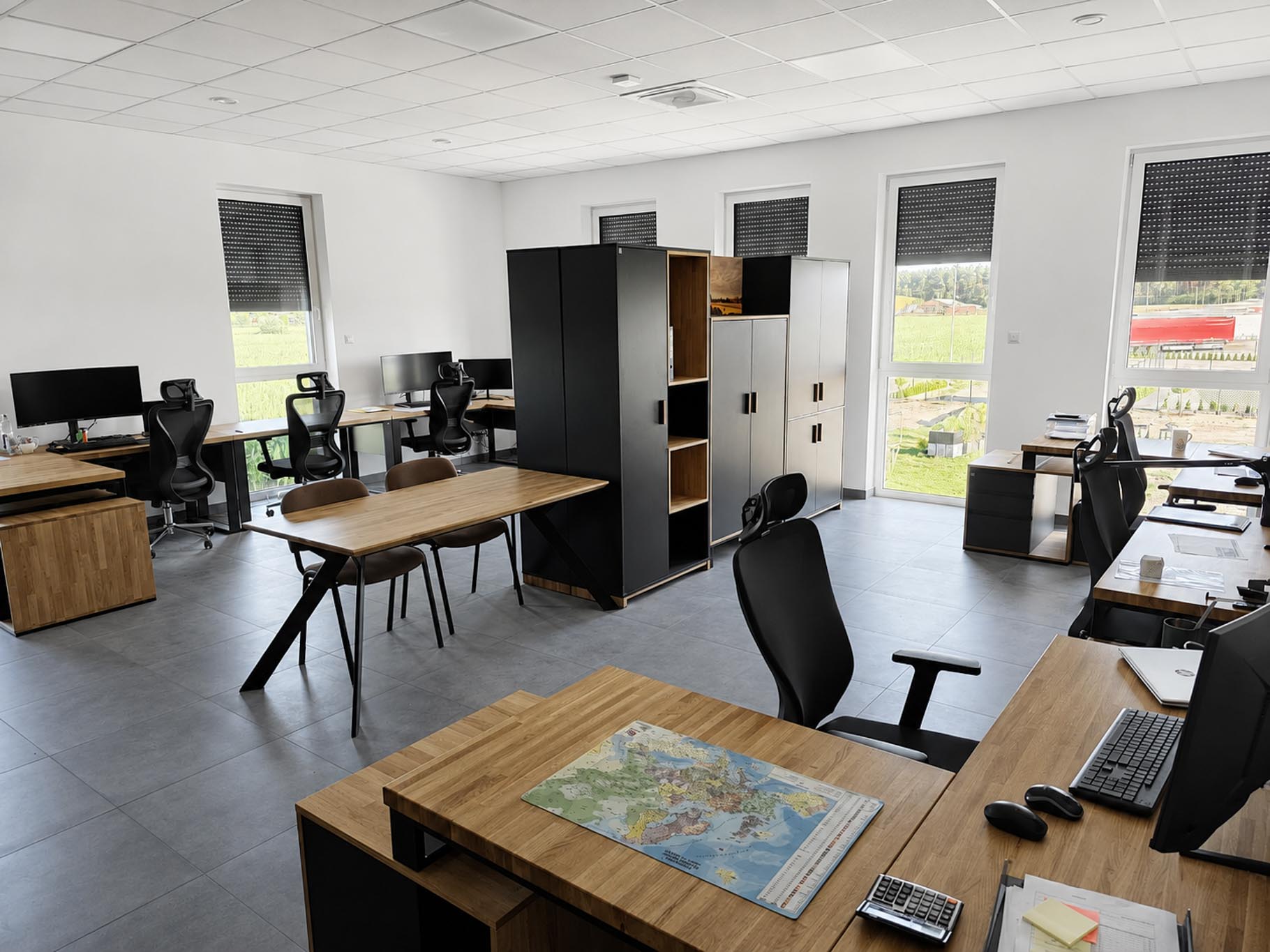 Wielostanowiskowe biuro open space z drewnianymi biurkami