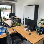 Nábytek do moderní kanceláře s dřevěnými deskami a černými čely